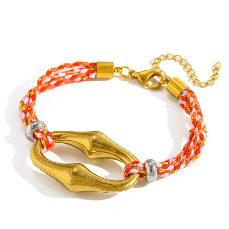 Bracelet with gold clasp and orange and white braided cord on a white background