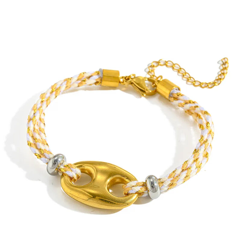Gold and white braided bracelet on a white background